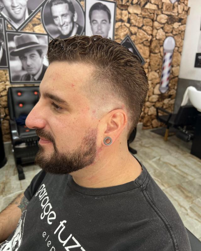Corte com topete e barba, de perfil