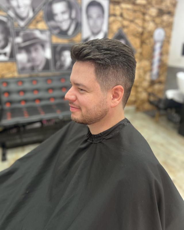 Corte curto com degradê, cliente sorrindo